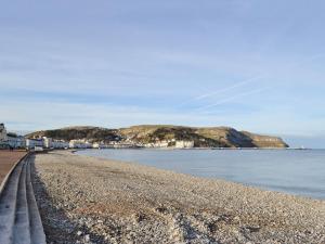 uma vista para uma praia com casas e a água em The Stables At Old Vicarage Cottage em Abergele