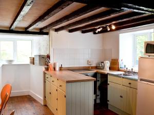 a kitchen with white cabinets and a counter top at Cae Cynddelw in Pale