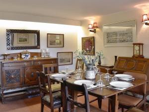 uma sala de jantar com uma mesa de madeira e cadeiras em Dalvanie Mill - S4241 em Tulchan