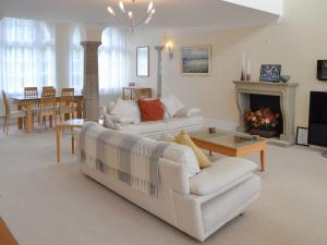 a living room with two white couches and a fireplace at 2 The Courtyard in Portreath
