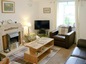 uma sala de estar com um sofá e uma lareira em Bydand Cottage em Melness