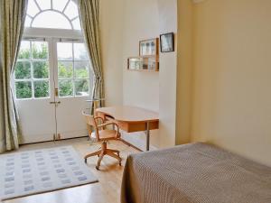 a bedroom with a bed and a desk and a window at 2 The Courtyard in Portreath