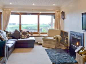 a living room with a couch and a fireplace at Woodend Bungalow in Hucknall under Huthwaite