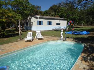a swimming pool with two chairs and a kite in a yard at Estalagem das Estrelas in Cristalina