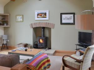 a living room with a wood stove in a living room at Brow View Cottage in Ravenstonedale