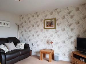 a living room with a couch and a tv at Limetrees in Keswick