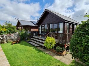 ein kleines Haus mit einer Terrasse und einem Hof in der Unterkunft Herons View - 28279 in Brundall