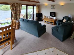 ein Wohnzimmer mit zwei blauen Sofas und einem TV in der Unterkunft Herons View - 28279 in Brundall