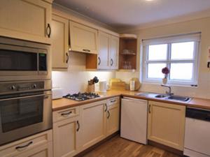 a kitchen with white cabinets and a stove top oven at Ty Gwyn - Hw7322 in Haverfordwest