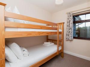 a bedroom with two bunk beds and a window at Cleets Retreat in Seahouses