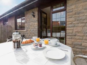 a table with two plates of food and orange juice at Cleets Retreat in Seahouses