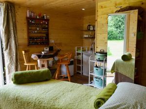 a room with a bed and a kitchen in a cabin at Robins Nest - 29409 in Elmsted
