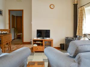 a living room with two couches and a tv at Stables-23893 in Aylmerton