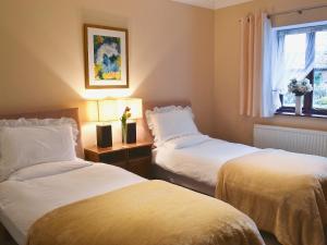 a hotel room with two beds and a window at Boundary Gallery Cottage in Framlingham