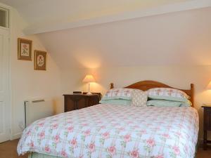 een slaapkamer met een groot bed en 2 lampen bij Strawberry Cottage in Kinlet