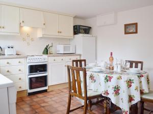 a kitchen with a table with a table cloth on it at Strawberry Cottage in Kinlet