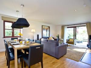 a dining room and living room with a table and chairs at Holly in Saint Wenn