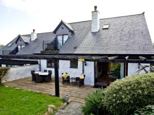 a house with a wooden deck with a table and chairs at Holly in Saint Wenn