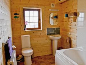 een badkamer met een toilet, een wastafel en een bad bij No, 6 Lake View Lodges - 28283 in Leake Common Side