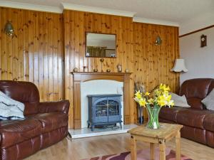 uma sala de estar com um sofá e uma lareira em Bute Cottage em Daliburgh
