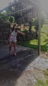 a young girl standing in front of a stone wall at Casa de Campo Província Minosso in Farroupilha