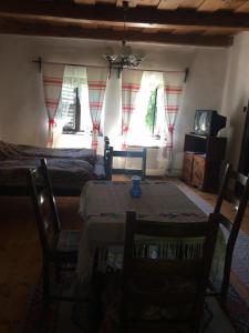 um quarto com uma mesa, cadeiras e janelas em Vén Diófa Kúria em Balaton