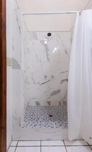 y baño con ducha y cortina de ducha. en Sea Eye Hotel - Sunset Building en Utila