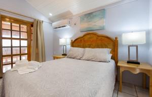 1 dormitorio con 1 cama con 2 mesas y 2 lámparas en Sea Eye Hotel - Sunset Building en Utila