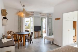 a living room with a table and a bedroom at Parosland Hotel in Aliki