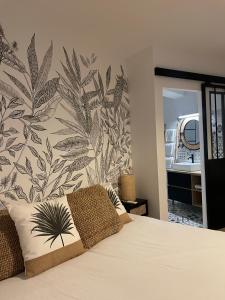 a bedroom with a bed with a tropical wallpaper at Hôtel Restaurant La Caravelle in Sari Solenzara