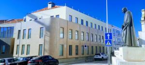 un gran edificio con coches estacionados frente a él en Light Brown Central Apartment, en Aveiro