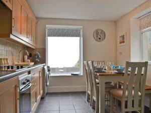 a kitchen with a table and chairs and a window at Wendon in Criccieth