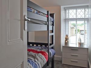 a bedroom with a bunk bed and a dresser at Wendon in Criccieth