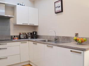 uma cozinha com armários brancos e uma tigela de fruta no balcão em Castle Dairy - 27901 em Ceres