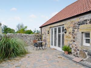 Cette maison en pierre dispose d'une terrasse avec une table et des chaises. dans l'établissement Castle Dairy - 27901, à Ceres