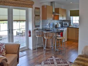 a kitchen with a bar with stools in it at The Snug in Valley