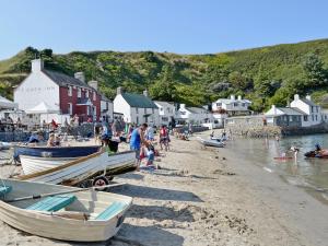 a group of people on a beach with boats at The Penthouse in Morfa Nefyn