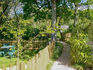 een houten hek in een tuin met een tafel en een bank bij Oaktree Cottage in Appledore
