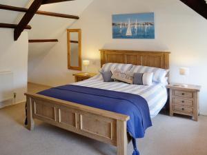 a bedroom with a large bed with blue and white sheets at Dover Row Cottage in Zelah