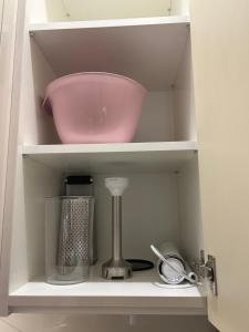 un estante con un tazón rosa y otros artículos de cocina en apartment in the city center en Split