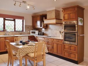 a kitchen with wooden cabinets and a table with chairs at Gearys in Freshwater