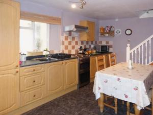 a kitchen with a table and a sink and a stove at The Briars in Lydbrook