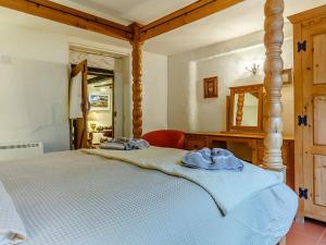 a bedroom with a large bed with a blue comforter at Laity in Polperro