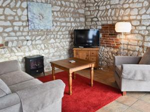 a living room with a couch and a table and a tv at Fulmar Cottage in Flamborough