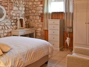 a bedroom with a bed and a desk and a window at Fulmar Cottage in Flamborough
