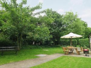 una mesa de picnic y una sombrilla en un patio en Beech Cottage - 27523, en Sewerby