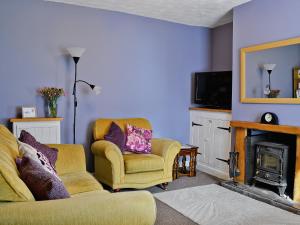a living room with a couch and a fireplace at Little Tern in Winterton-on-Sea