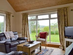 a living room with a couch and a tv at Riverview Cottage in Acharacle