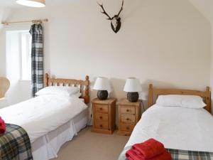 two beds sitting next to each other in a bedroom at Keepers House in Glenrossal