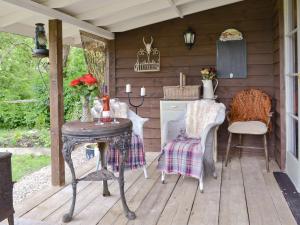 an outdoor kitchen with a table and chairs on a porch at Woodlands in Elsenham